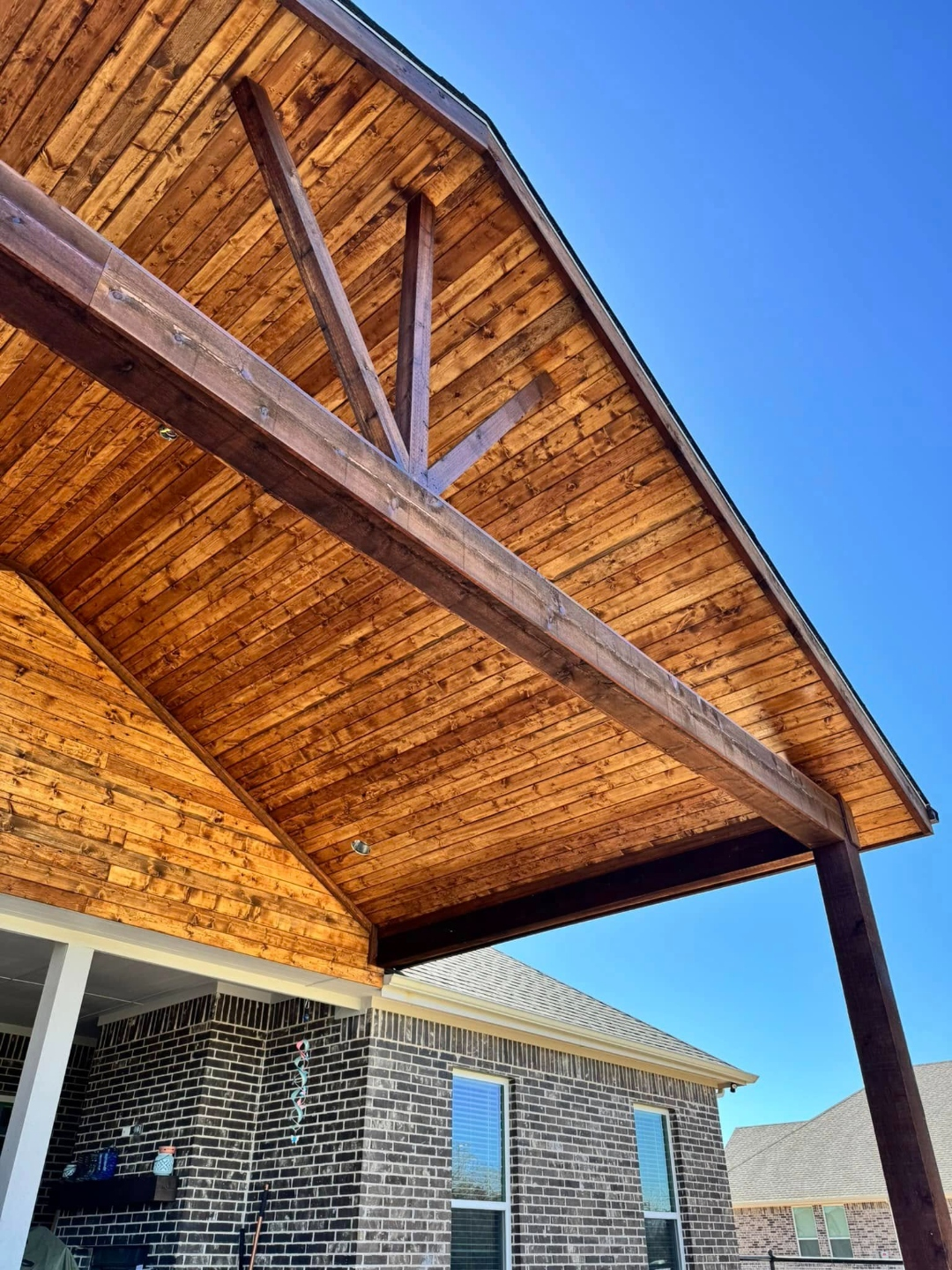 Vaulted cedar patio cover attached to a brick home