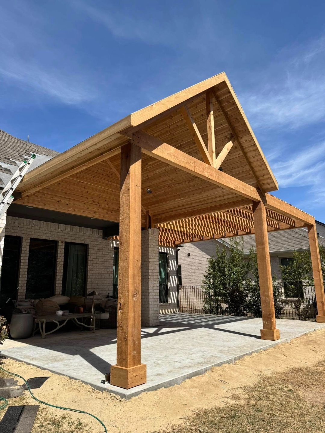 Attached gable patio cover connected to an open slat pergola with outdoor furniture