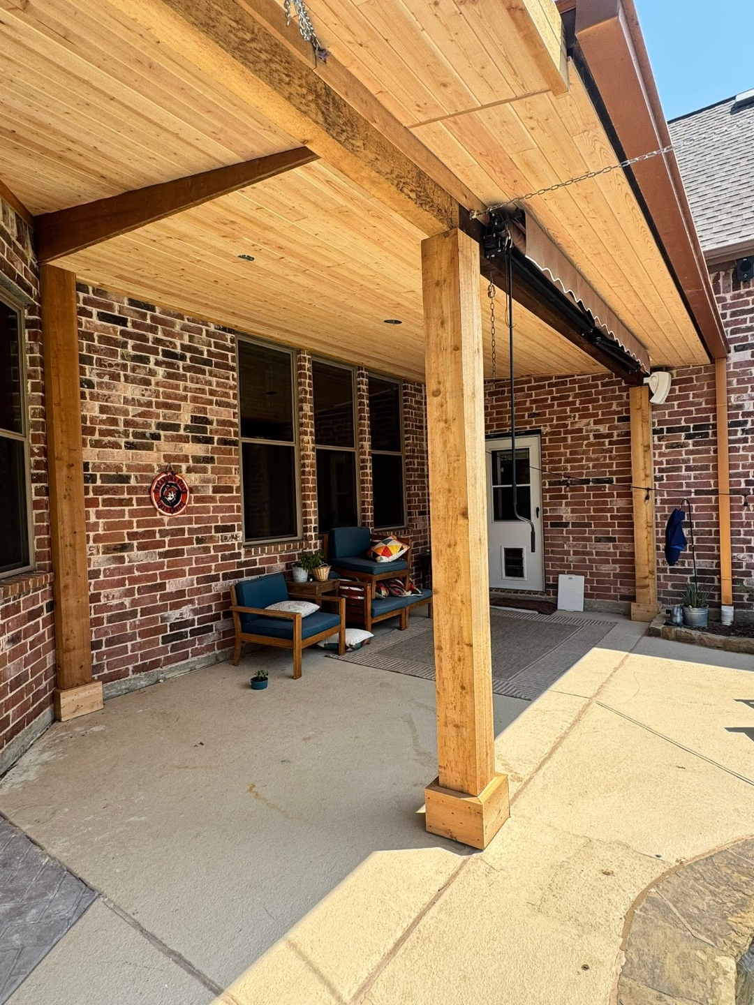 Cedar patio cover with a retractable awning and outdoor seating