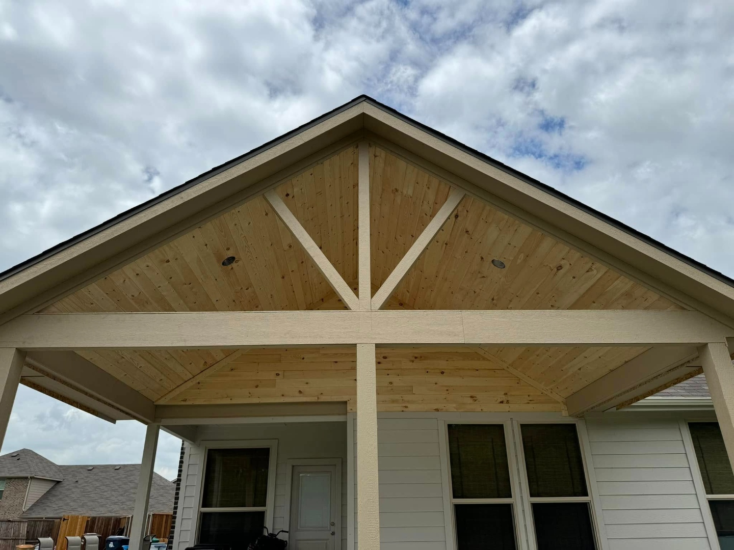 Vaulted gable patio cover with recessed lighting against a blue sky